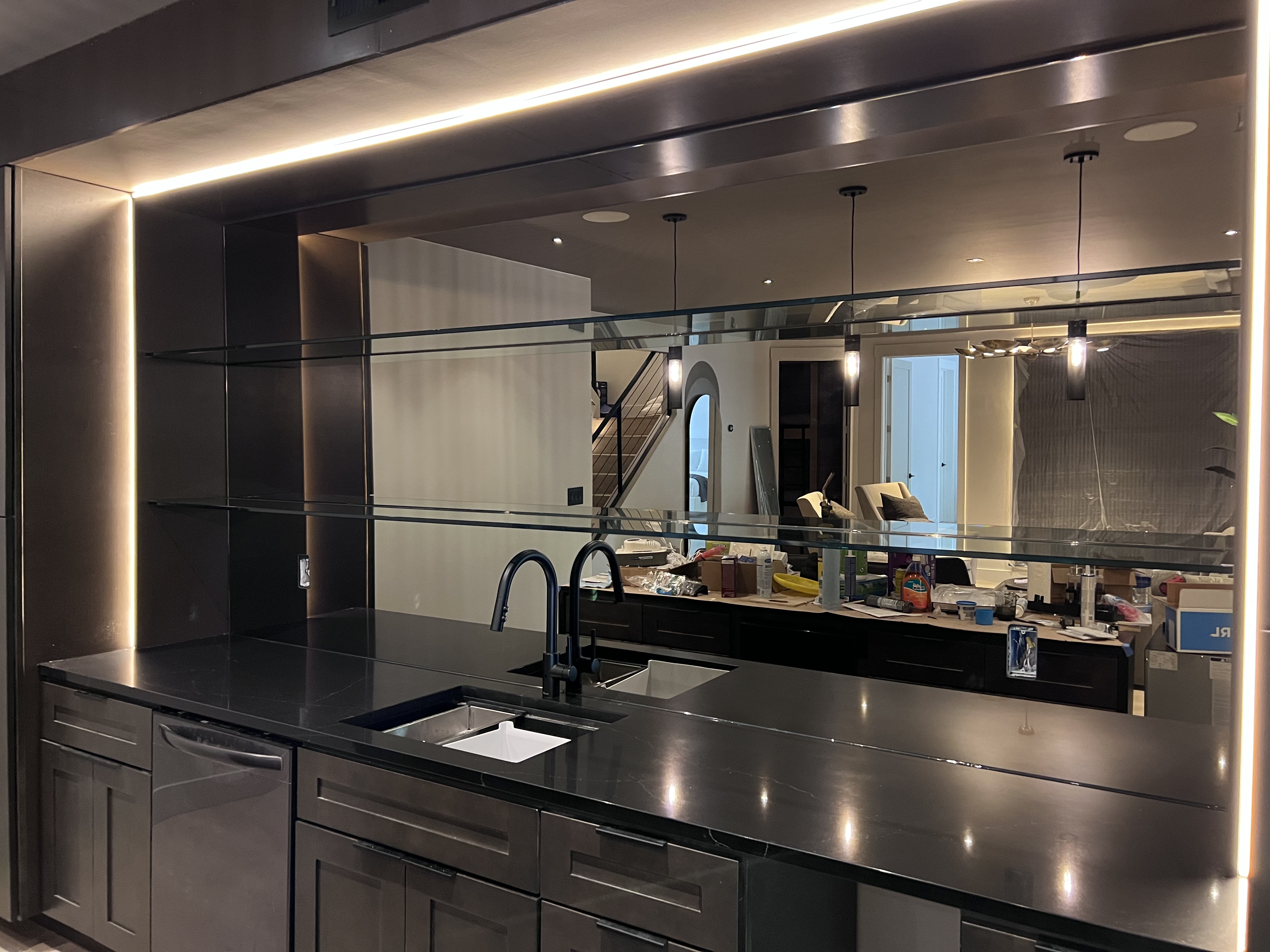 These floating glass bar shelves are supported by a bronze mirror backsplash!