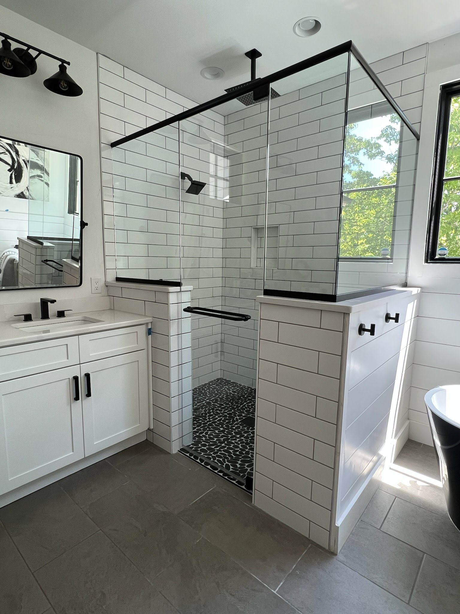 This shower door was actually removed and re-tiled before installing it in place again. The curb had been lifted which resulted in the door being taller than the panels next to it. In order to save the homeowner money and re-use good glass, we used aluminum header bars underneath the fixed panels to raise them up! Our technicians were very creative in their approach and provided the customer with a gorgeous enclosure!