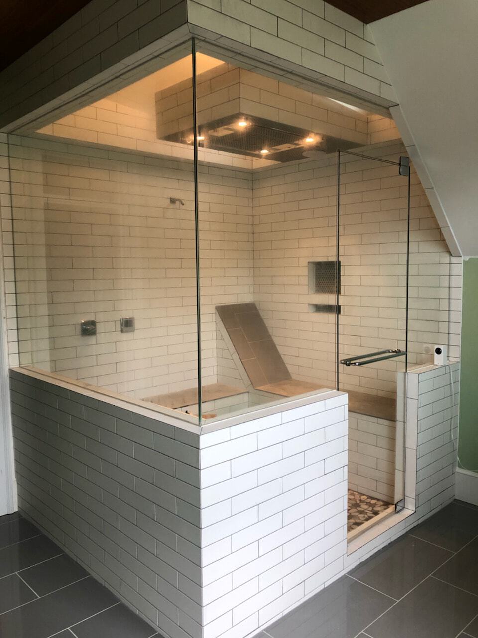 Door is hinged off of one single piece of glass with no seams. This is not a separate transom or a separate set of side panels, rather, the door is fully encapsulated by a single, custom cut piece.