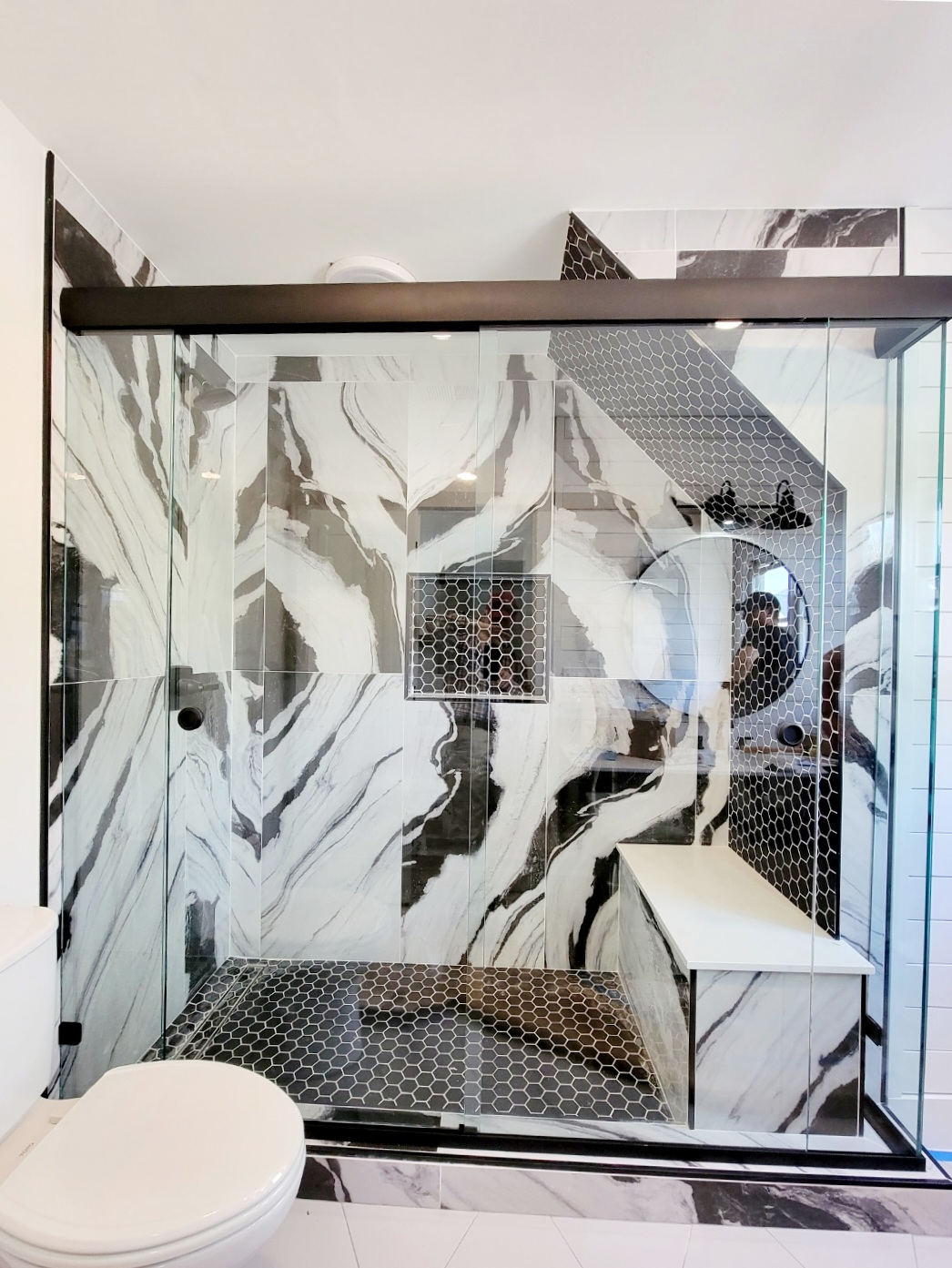 This slider is called a Cottage Slider and features three fixed panels with two bypassing slider panels. This is an extremely tricky installation, but the outcome will allow the homeowner to access the faucet, clean the bench seat area, and will not affect the toilet.