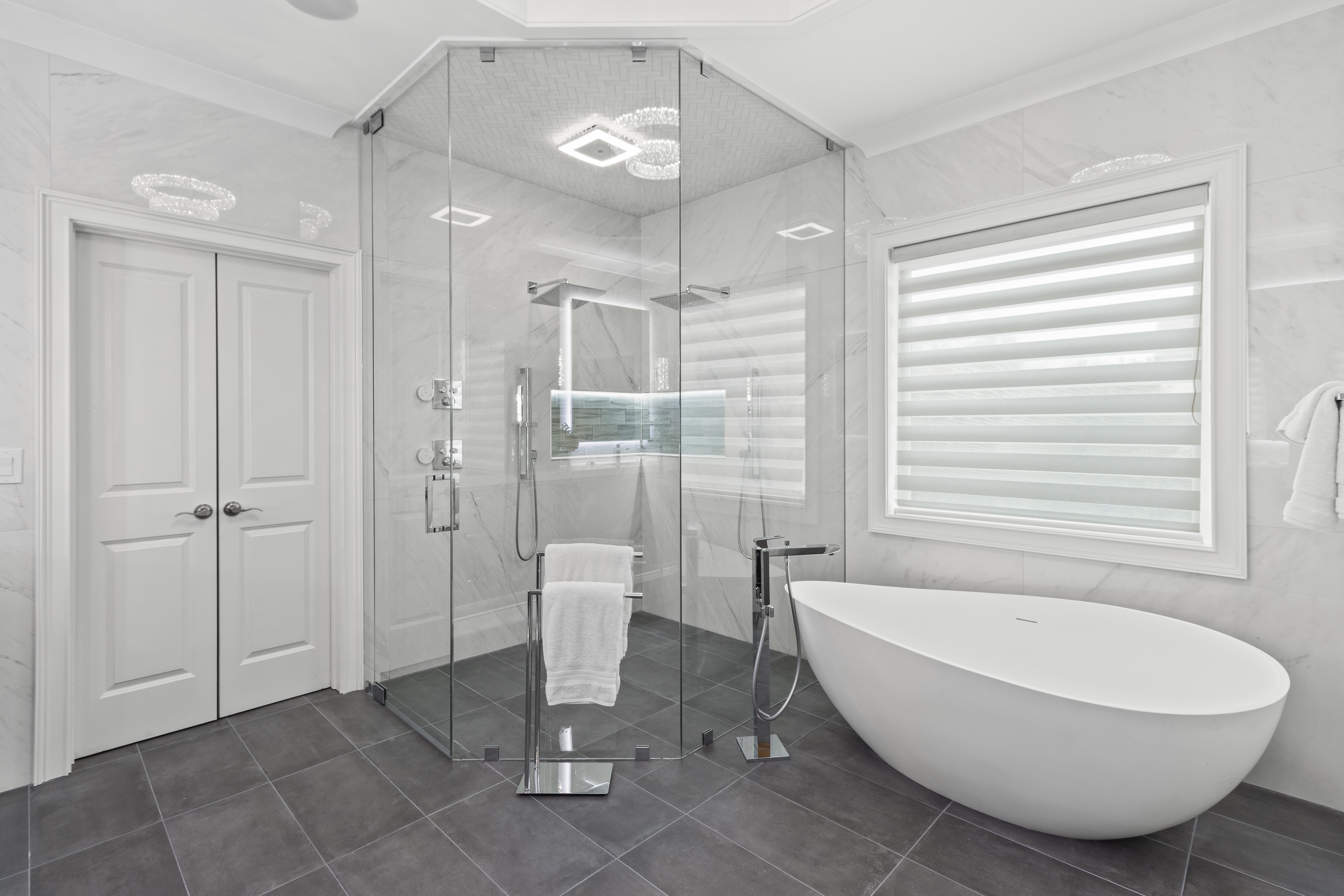 This stunning neo-angle shower completes the luxurious look of this new bathroom remodel by Stephenson Construction.