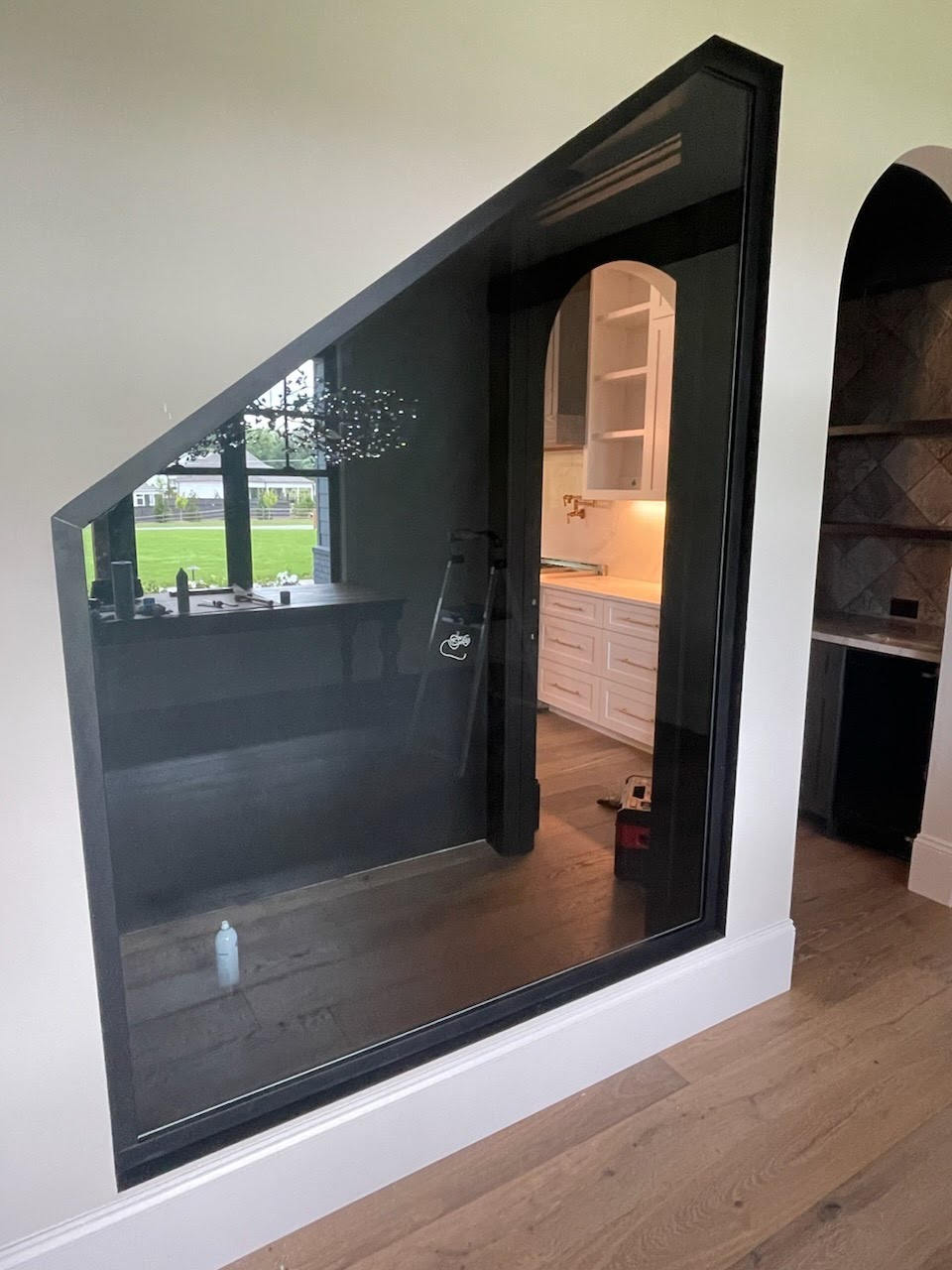 This complex shape encloses a wine cellar underneath the stairwell in a residential property. Ask us how you can transform your space into a wine room today! We can also add LED lighting inside the frame to illuminate the edges of the glass for a more dramatic effect.