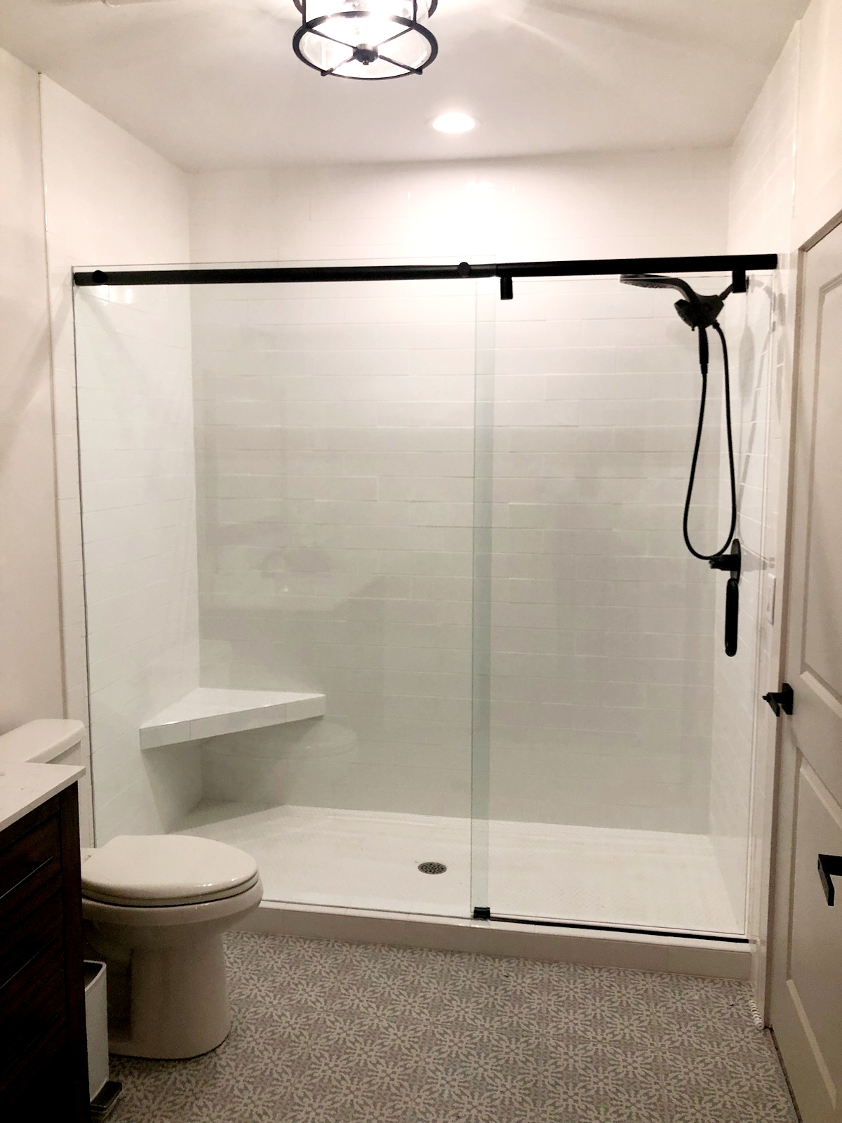 This sliding system is called and Hydroslide. It is a barn style slider with a sleek look that hides the rollers in its bar. The door hangs beneath the bar making it slightly shorter than the adjacent panel.